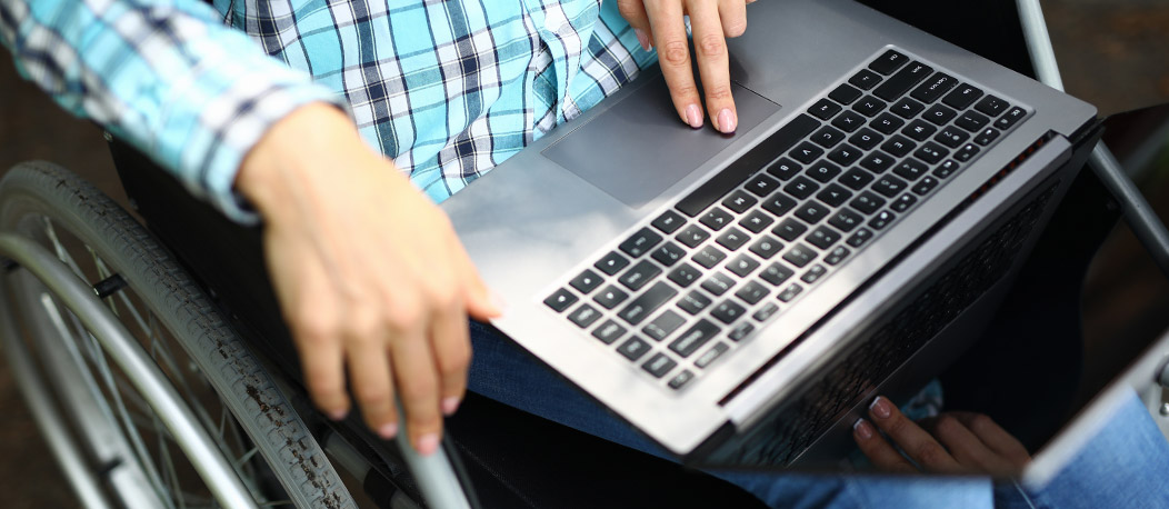 Usuário de cadeira de rodas usando um laptop.